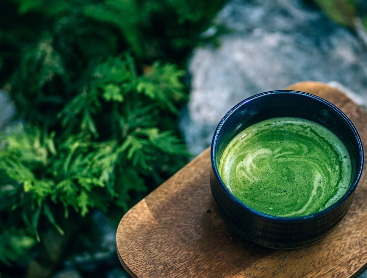 A japanese ceramic cup filled with a vibrant matcha green tea latte